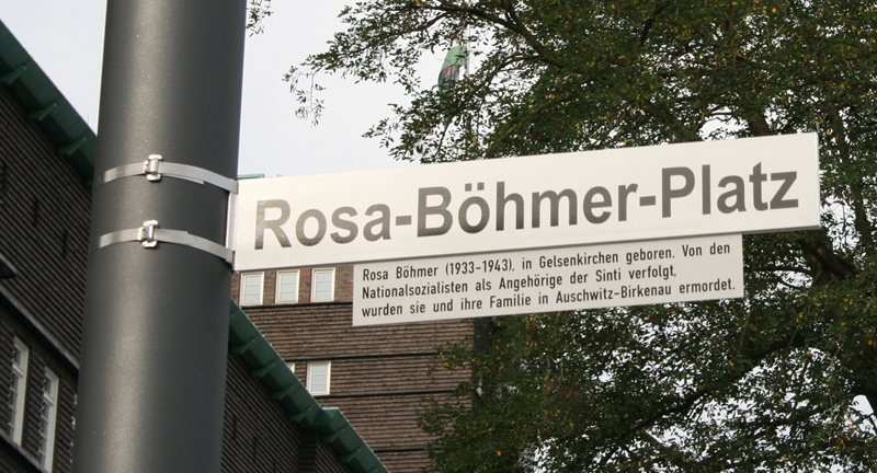 Ein Zusatzschild verweist auf den gewaltsamen Tod der Sinti-Familie Böhmer im Vernichtungslager Auschwitz-Birkenau